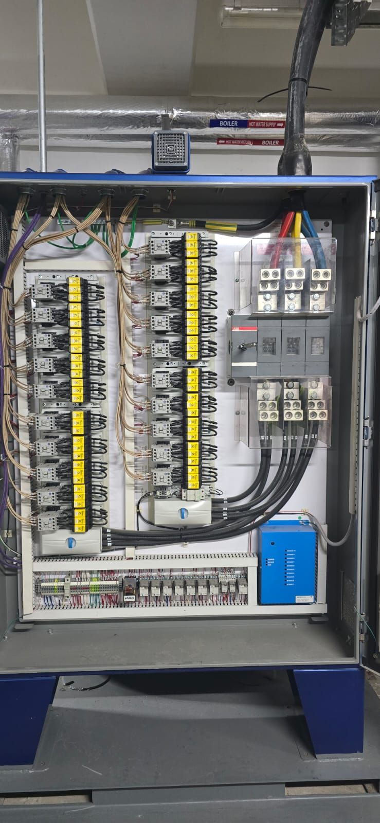 Blue-enclosure control panel with multiple rows of relays and busbar connections