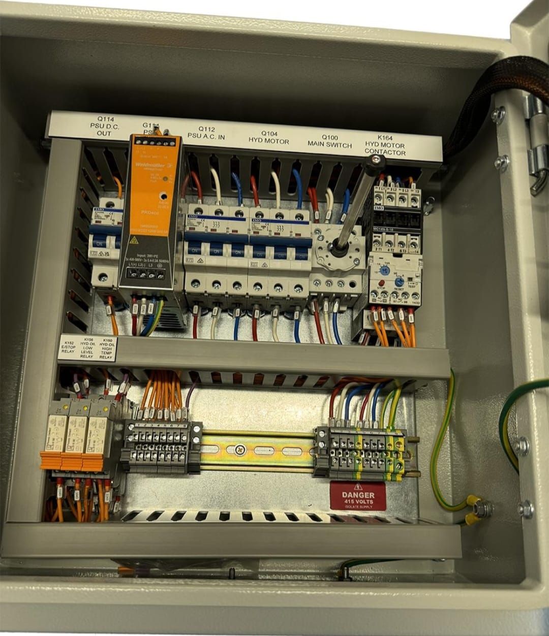 PLC power supply, circuit breakers and labelled I/O terminal blocks inside a control cabinet